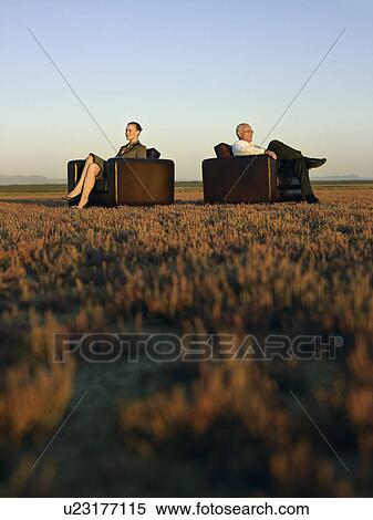 Businesspeople sitting in armchairs on open plain View Large Photo Image Stock Photography - Businesspeople sitting in armchairs on open plain. Fotosearch