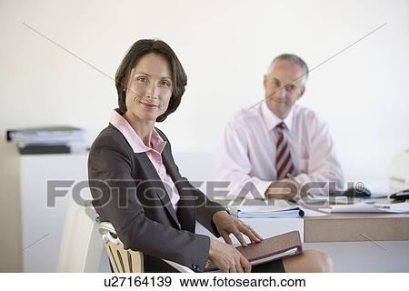 Stock Photo - Businesswoman and businessman in office.. Fotosearch