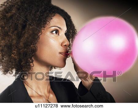 Stock Photo - Businesswoman Blowing up Balloon. Fotosearch