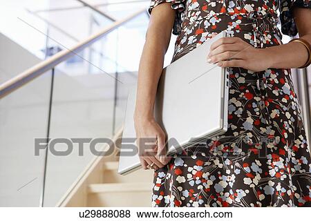 Businesswoman holding Laptop on Staircase mid section View Large Photo Image Stock Photo - Businesswoman holding Laptop on Staircase mid section. Fotosearch