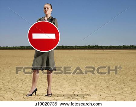 Businesswoman holding 'no entry' sign in desert full length View Large Photo Image Stock Photography - Businesswoman holding 'no entry' sign in desert full length. Fotosearch