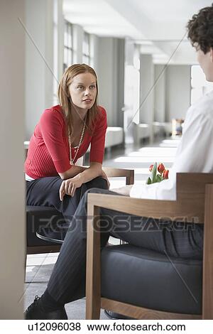 Stock Photo - Businesswoman sitting talking to businessman. Fotosearch