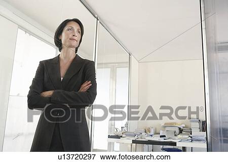 Businesswoman standing in office low angle view. View Large Photo Image Stock Photo - Businesswoman standing in office low angle view.. Fotosearch
