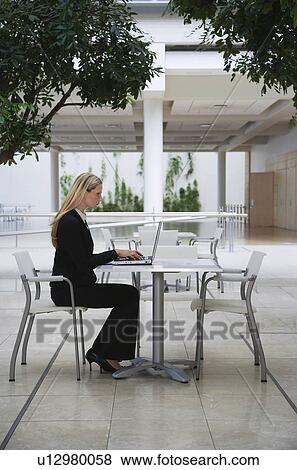 Stock Photo - Businesswoman using laptop outdoors. Fotosearch