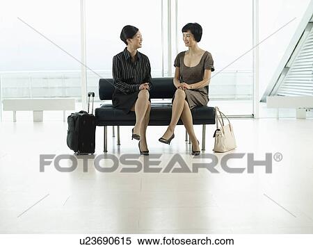 Businesswomen Sitting legs crossed on Bench in airport before flight View Large Photo Image Stock Photography - Businesswomen Sitting legs crossed on Bench in airport before flight. Fotosearch