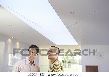 Stock Image - Casually dressed Businessmen interacting in Office. Fotosearch