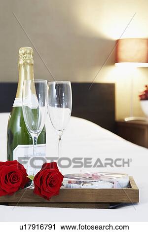 Stock Image - Champagne and flutes on bed. Fotosearch