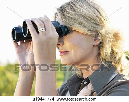 Close-up of adult woman looking through binoculars View Large Photo Image Picture - Close-up of adult woman looking through binoculars. Fotosearch