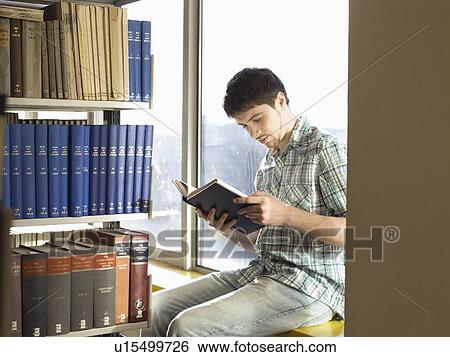 Stock Photograph - College Student Reading in Library. Fotosearch