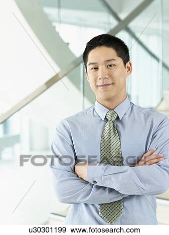 Stock Photo - Confident Businessman standing arms crossed. Fotosearch