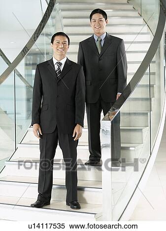 Confident Businessmen standing on staircase View Large Photo Image Stock Photography - Confident Businessmen standing on staircase. Fotosearch