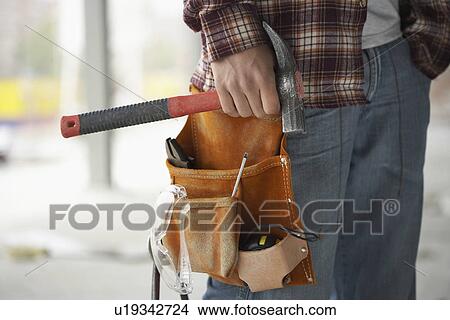 Picture - Construction worker wearing tool belt mid section. Fotosearch