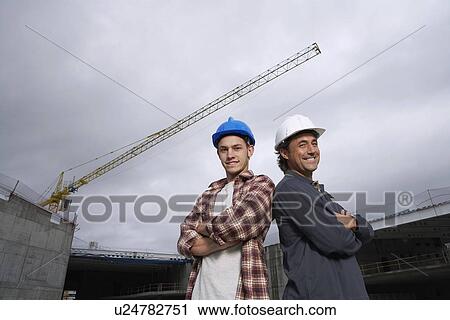 Stock Image - Construction workers on building site. Fotosearch