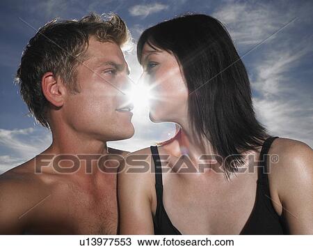 Couple about to kiss with sun behind outdoors View Large Photo Image Stock Image - Couple about to kiss with sun behind outdoors. Fotosearch