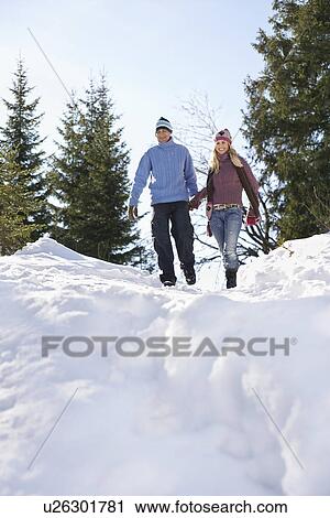 Couple descending snow-covered hill low angle view View Large Photo Image Stock Image - Couple descending snow-covered hill low angle view. Fotosearch