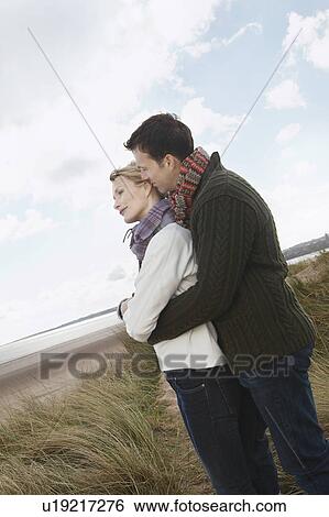 Couple embracing at ocean View Large Photo Image Stock Photograph - Couple embracing at ocean. Fotosearch