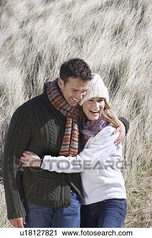 Couple embracing in long grass View Large Photo Image Stock Image - Couple embracing in long grass. Fotosearch