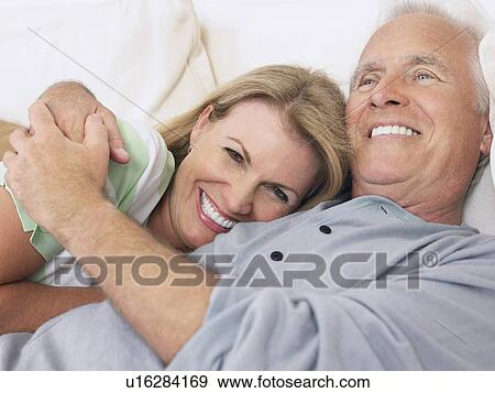 Stock Photo - Couple embracing lying in bed. Fotosearch