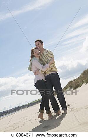 Couple embracing on beach View Large Photo Image Stock Image - Couple embracing on beach. Fotosearch