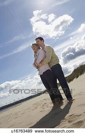 Couple embracing on beach View Large Photo Image Stock Photo - Couple embracing on beach. Fotosearch
