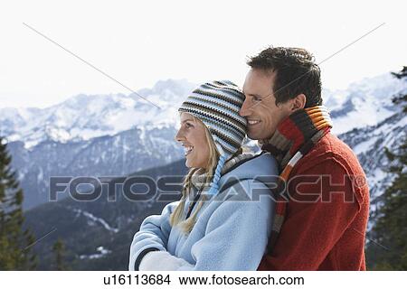Picture - Couple embracing on mountain peak side view. Fotosearch
