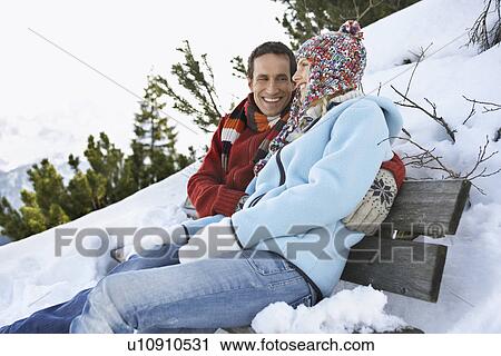 Couple embracing sitting on bench on hillside side view View Large Photo Image Stock Image - Couple embracing sitting on bench on hillside side view. Fotosearch