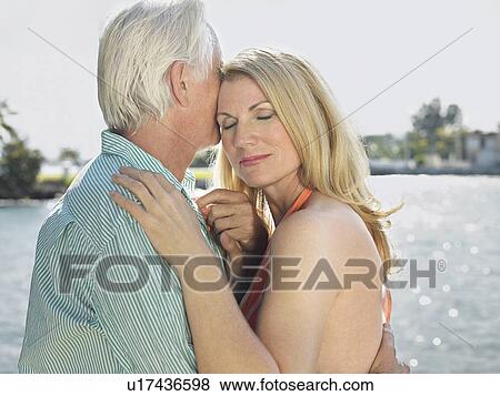 Couple embracing standing by river View Large Photo Image Stock Photo - Couple embracing standing by river. Fotosearch