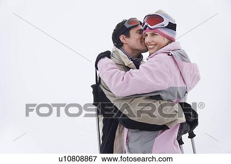 Stock Photo - Couple embracing standing in snow. Fotosearch