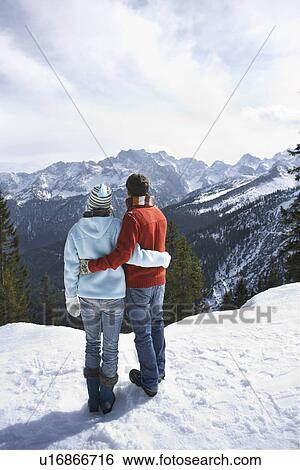 Couple looking at view from mountain peak back view View Large Photo Image Stock Photograph - Couple looking at view from mountain peak back view. Fotosearch