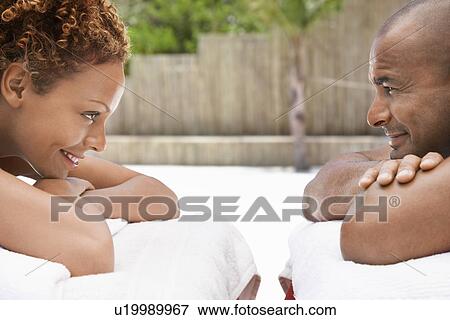 Couple lying on massage tables face to face head and shoulders View Large Photo Image Stock Photo - Couple lying on massage tables face to face head and shoulders. Fotosearch