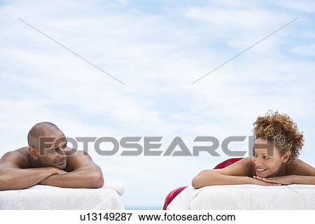 Couple lying on massage tables outside head and shoulders View Large Photo Image Stock Photo - Couple lying on massage tables outside head and shoulders. Fotosearch