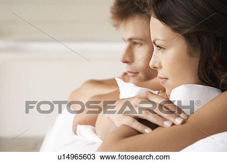 Couple lying on stomachs in bed head and shoulders profile View Large Photo Image Stock Image - Couple lying on stomachs in bed head and shoulders profile. Fotosearch