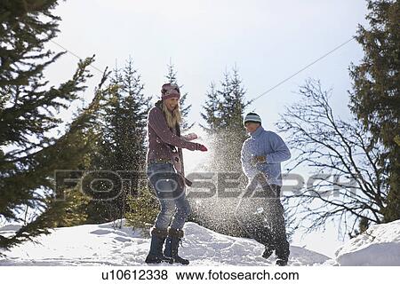 Couple playing in snow on hill View Large Photo Image Stock Photo - Couple playing in snow on hill. Fotosearch