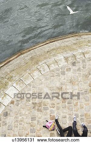Stock Image - Couple Relaxing by canal low section view from above. Fotosearch