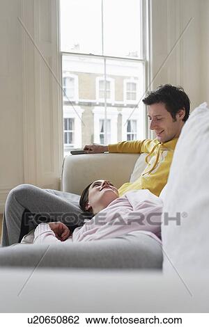 Couple relaxing on sofa View Large Photo Image Stock Image - Couple relaxing on sofa. Fotosearch