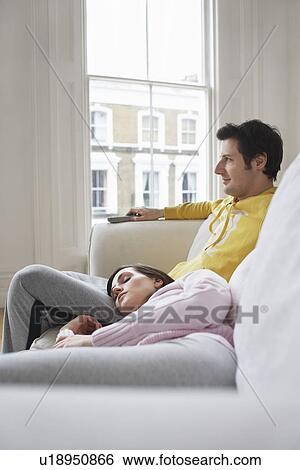 Couple relaxing on sofa View Large Photo Image Stock Photograph - Couple relaxing on sofa. Fotosearch