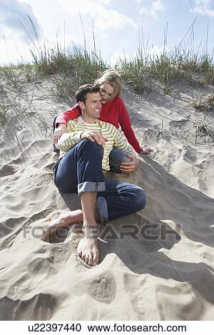 Couple sitting on beach embracing View Large Photo Image Stock Image - Couple sitting on beach embracing. Fotosearch