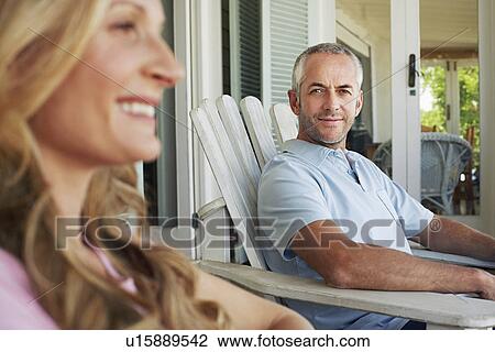 Couple sitting on porch smiling focus on man View Large Photo Image Stock Image - Couple sitting on porch smiling focus on man. Fotosearch