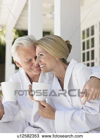 Couple sitting on verandah holding coffee cups View Large Photo Image Stock Image - Couple sitting on verandah holding coffee cups. Fotosearch