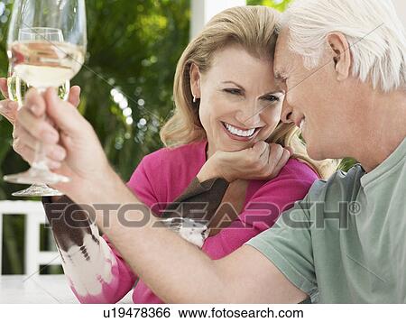 Stock Photograph - Couple toasting with wine glasses. Fotosearch