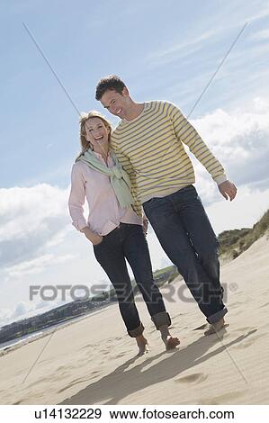 Stock Photo - Couple walking on beach. Fotosearch
