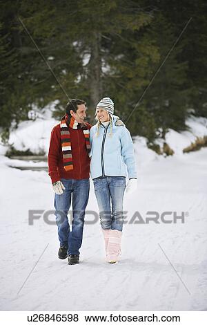 Stock Photo - Couple walking on snow-covered path. Fotosearch
