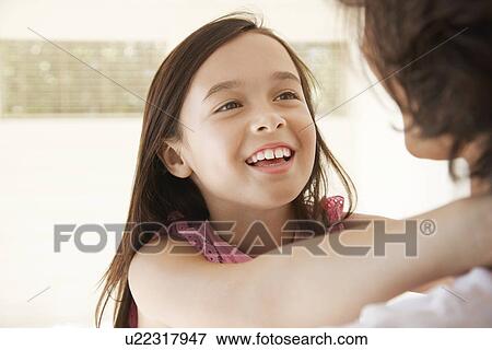 Stock Photo - Daughter with arms round mother's neck head and shoulders. Fotosearch