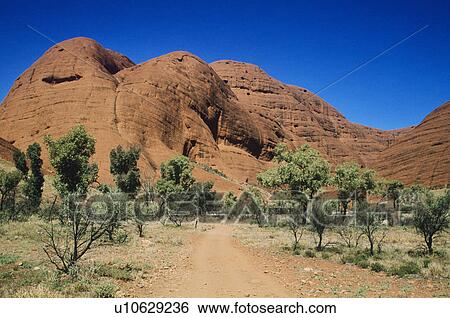 Stock Photograph - Dirt track leading towards rock formation. Fotosearch