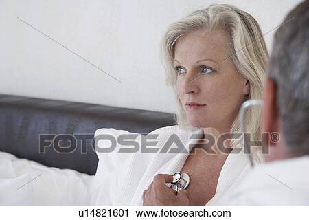Doctor doing house call on mature woman in bed using stethoscope close-up View Large Photo Image Stock Image - Doctor doing house call on mature woman in bed using stethoscope close-up. Fotosearch