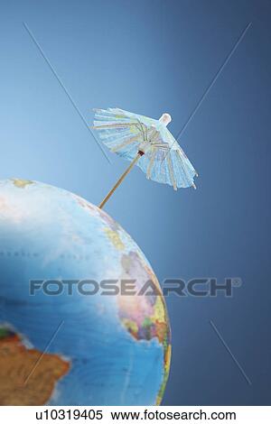 Stock Photography - Drink umbrella on globe studio shot low angle view. Fotosearch