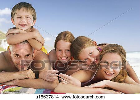 Picture - Family lying on beach. Fotosearch