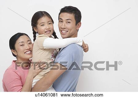 Family portrait of father holding daughter mother hugging on other side side view View Large Photo Image Stock Image - Family portrait of father holding daughter mother hugging on other side side view. Fotosearch