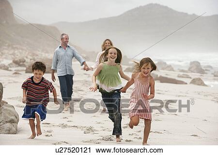 Family with three children (5-6 7-9 10-12) walking on beach View Large Photo Image Stock Image - Family with three children (5-6 7-9 10-12) walking on beach. Fotosearch