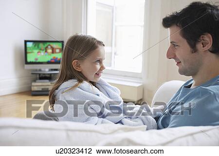 Father and daughter (5-6) relaxing on sofa in living room View Large Photo Image Stock Image - Father and daughter (5-6) relaxing on sofa in living room. Fotosearch